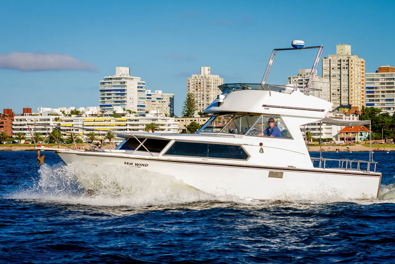 Yate de pesca con flybridge navegando frente a la costa de Punta del Este